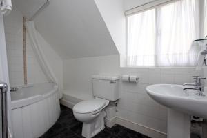 Baño blanco con aseo y lavamanos en White Hart, Andover by Marston's Inns en Andover