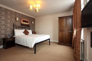 um quarto com uma cama e uma televisão de ecrã plano em White Hart, Andover by Marston's Inns em Andover