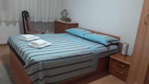 a bedroom with a bed with blue pillows and a chair at Apartment VASSA in Kotor