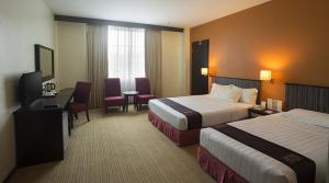 a hotel room with two beds and a television at Hotel Seri Malaysia Lawas in Lawas +25 photos