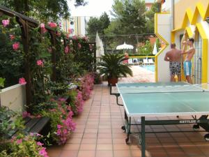 a ping pong table on a patio with flowers at Hotel Europa in Bibione