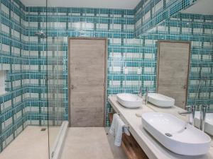 a bathroom with two sinks and a shower at Bahia Mar Beach House in Vilanculos