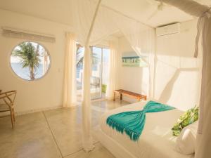 a bedroom with a white bed and a window at Bahia Mar Beach House in Vilanculos