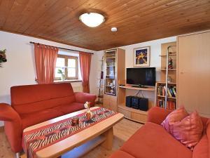 a living room with a couch and a tv at Holiday home in Rattersberg Bavaria with terrace in Viechtach