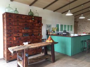 una cocina con mesa de madera y una isla verde en Sa Bassa Crua Agroturismo, en Sa Torre