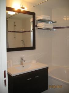 een badkamer met een wastafel, een spiegel en een bad bij Villa Lina in Bandol