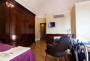 PianellaにあるDimora Antica Pianellaのベッドルーム1室(ベッド1台、ドレッサー、椅子2脚付)