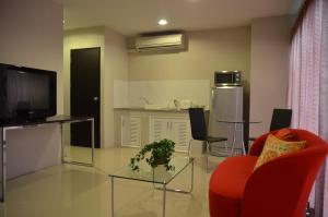 a living room with a red chair and a television at Bangkok Living in Bangkok