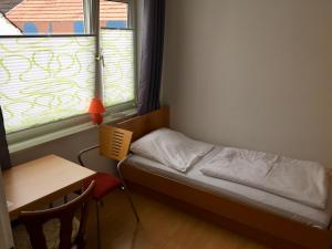 a small room with a bed and a desk and a window at Hotel Stadt Mainz in Schwabenheim +25 photos