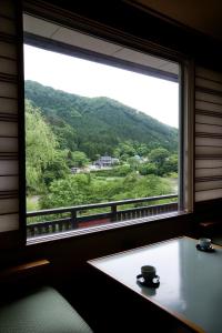 a window in a room with a view of a mountain at Kansyokan in Mogami