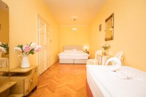 a bedroom with two beds and flowers in a room at Prague Siesta Apartments in Prague +54 photos