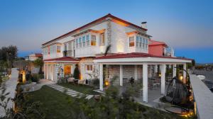 a large house with a porch on a street at Eritrina Alacati in Alacati