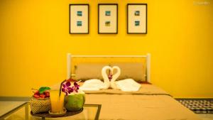 ラワイビーチにあるVii House Rawai Phuketの黄色の壁のベッドが備わる黄色の部屋