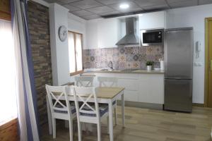 eine Küche mit einem Tisch und Stühlen sowie einem Kühlschrank in der Unterkunft Apartamento María in Baena