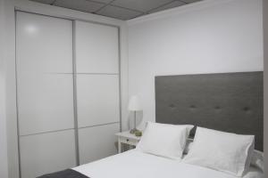 バエナにあるApartamento Maríaのベッドルーム(白いベッド、白い枕付)