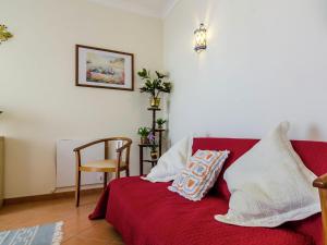 um sofá vermelho com almofadas num quarto em This warm and comfortable apartment em Lagos