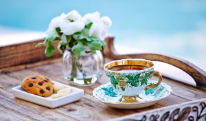 a table with a cup of tea and a cookie at Eritrina Alacati in Alacati