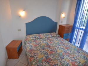 ポルト・ガリバルディにあるBelvilla by OYO Porto Garibaldi Trilo Doriaのベッドルーム1室(青いヘッドボード付きのベッド1台、ナイトスタンド付)