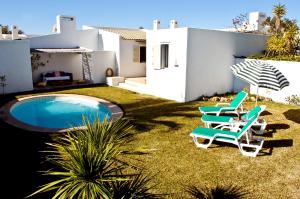 einen Garten mit zwei Stühlen und einem Pool in der Unterkunft Vila 832 in Albufeira