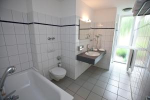 a white bathroom with a sink and a toilet at Hotel Rheinpark Rees in Rees
