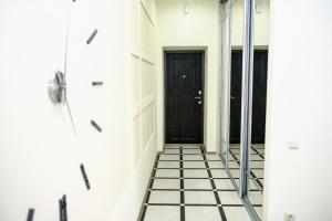 um corredor com uma porta preta e piso em azulejo em Family House em Vinnytsya