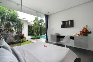 a bedroom with a bed and a desk and a tv at Villa Bahia by Optimum Bali Villas in Seminyak