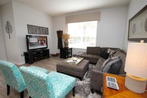 a living room with a couch and a tv at Cayview Condo #231537 in Orlando