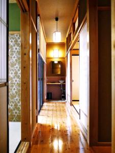 un pasillo con suelo de madera y una habitación con lavabo en K's Villa Hida-an, en Takayama