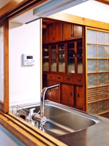 a kitchen with a stainless steel sink and wooden cabinets at K's Villa Hida-an in Takayama