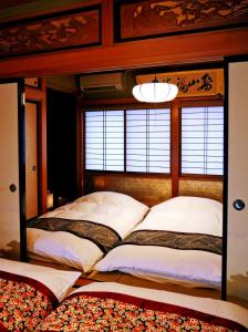 1 dormitorio con 2 camas y ventana en K's Villa Hida-an, en Takayama