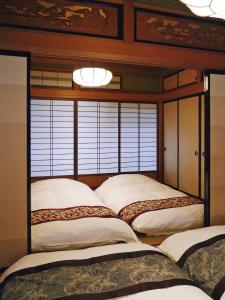 1 dormitorio con 2 camas y 1 cama con dosel en K's Villa Hida-an, en Takayama