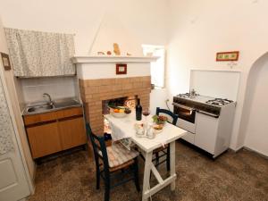 a small kitchen with a table and a fireplace at Belvilla by OYO Il Tesoro in Cisternino