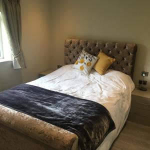 a bed with white sheets and pillows in a bedroom at Palms Cottage in Blackburn