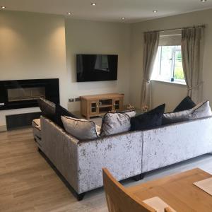 a living room with a couch and a television at Palms Cottage in Blackburn