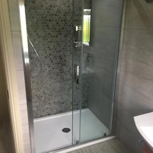 a shower with a glass door in a bathroom at Palms Cottage in Blackburn