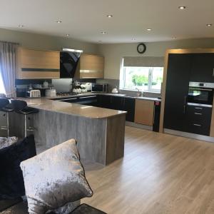 a large kitchen with a large island in the middle at Palms Cottage in Blackburn