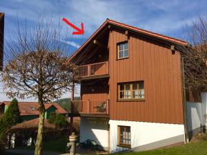 um papagaio vermelho está a voar sobre uma casa em Ferienwohnung Nele em Hillstett