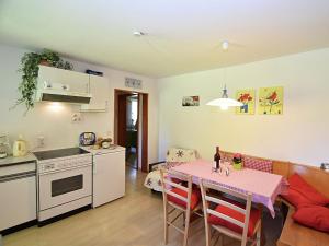 トリベルクにあるCountry style flat with gardenのキッチン、ダイニングルーム(ピンクのテーブルクロス付きのテーブル付)