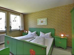 1 dormitorio verde con 1 cama grande con almohadas blancas en Country style flat with garden, en Triberg