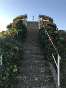 a stairway with flowers and a cross on the top at Vue mer à Arromanches in Arromanches-les-Bains