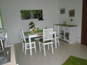 comedor con mesa blanca y sillas en Ferienwohnung Bambusgarten, en Mössingen