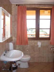 a bathroom with a sink and a toilet and a window at Monterama Apartments in Sutomore +56 photos