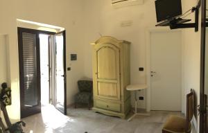 a living room with a wooden cabinet and a television at L'antico Trullo - Masseria Chiancarella in Fasano