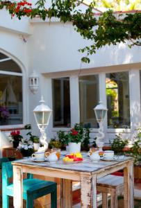 a wooden table with bowls of food on it at MR Hotelet de la Raconà & Apartments in Denia