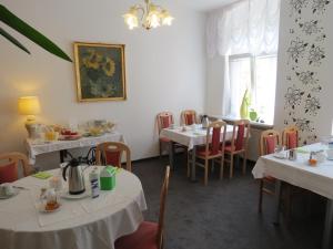 jadalnia z białymi stołami i krzesłami w obiekcie Hotel-Pension SCHLOSS -MIRAMAR w mieście Bad Elster