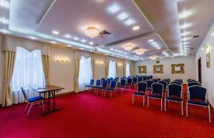salę konferencyjną z niebieskimi krzesłami, stołem, stołem i przewodniczącym w obiekcie Grein Hotel w mieście Rzeszów