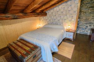 een slaapkamer met een bed in een kamer met houten plafonds bij Casa do Conto in Doade