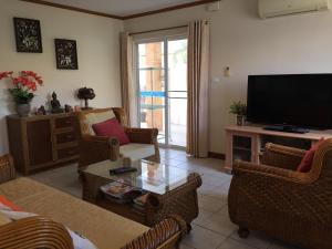 a living room with a flat screen tv and chairs at Villa Baansiesom in Sam Roi Yot