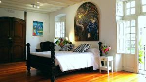 a bedroom with a bed and a painting on the wall at Hostal Palacio Jaureguia in Irurita