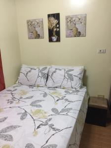 ein Bett in einem Schlafzimmer mit drei Bildern an der Wand in der Unterkunft SD4 Studio Apartment in Loculan